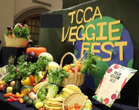 Many vegetables beautifully displayed on a table with TCCA Veggie Fest sign