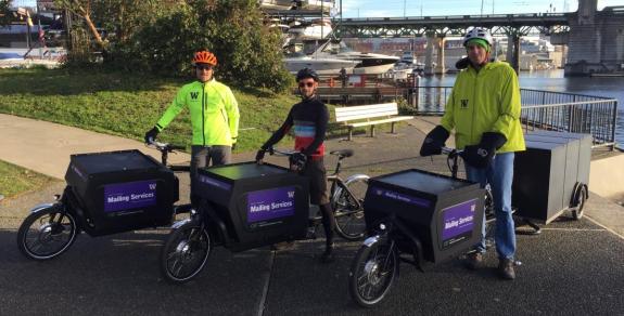 Three UW mail delivery staff with electric bikes