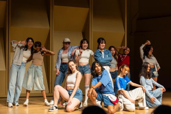 Group of dancers in white a blue outfits.