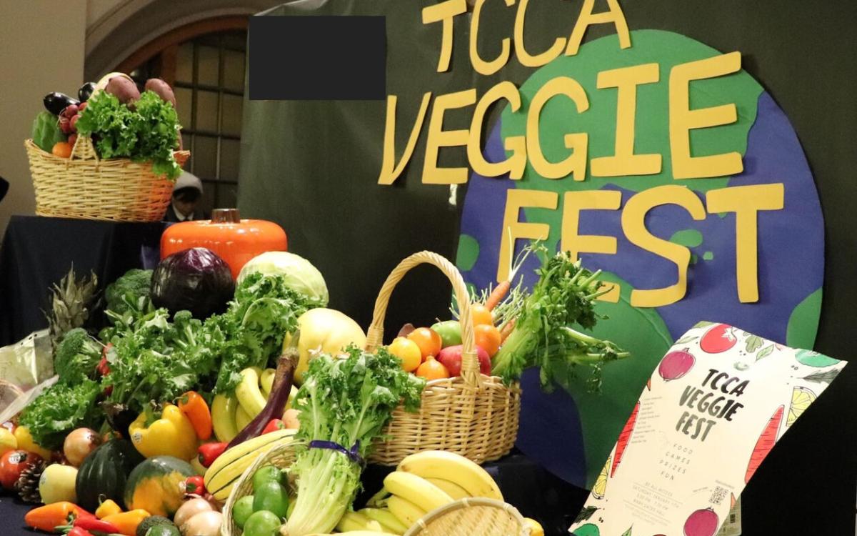 Many vegetables beautifully displayed on a table with TCCA Veggie Fest sign