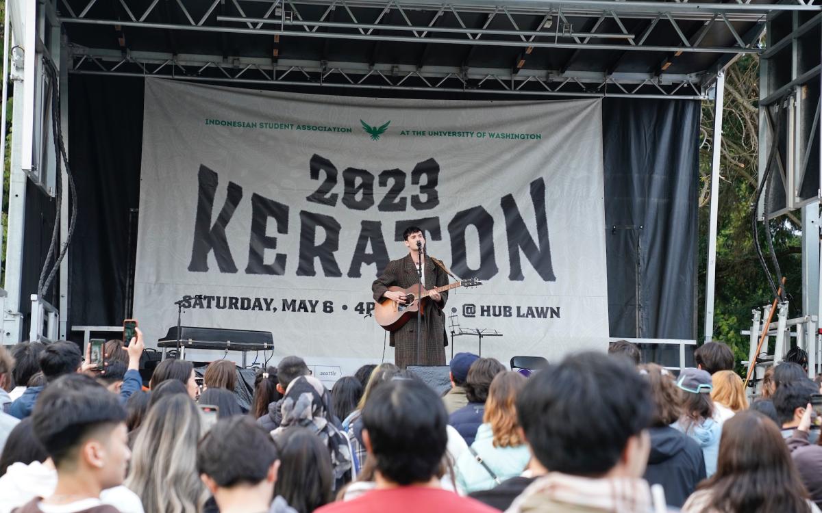 Musician standing on stage playing guitar 