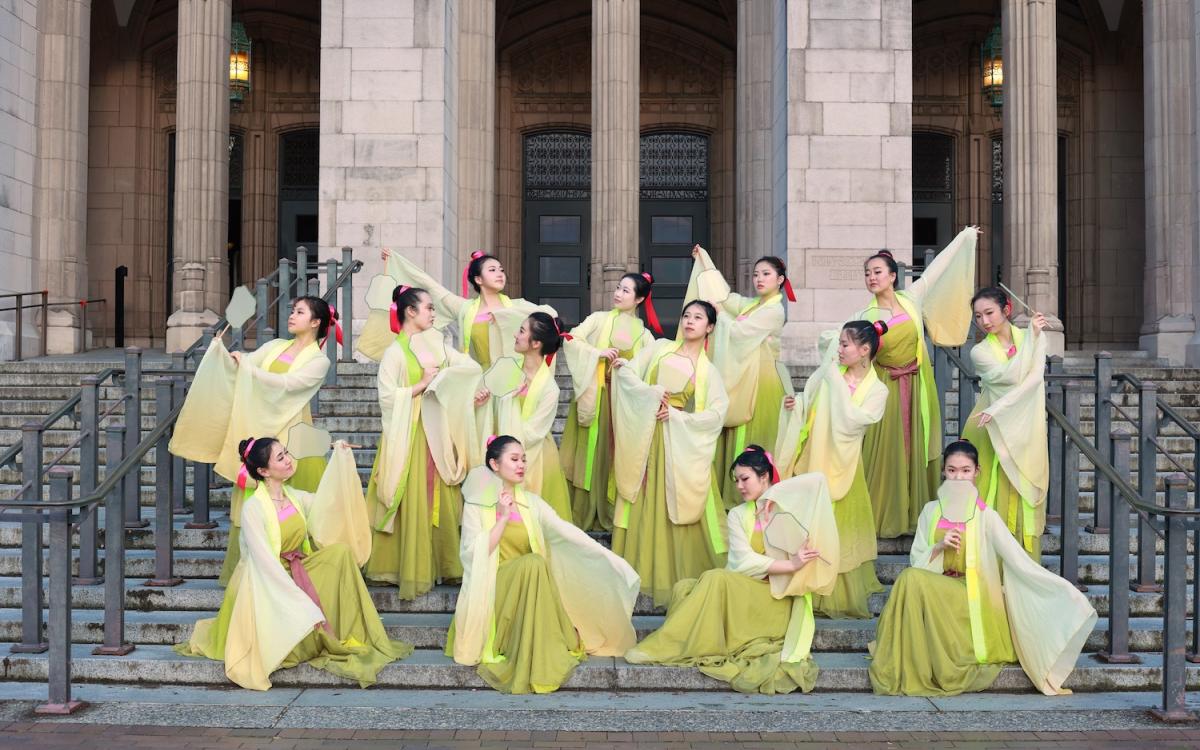 Group of students with traditional wear posing outside building 