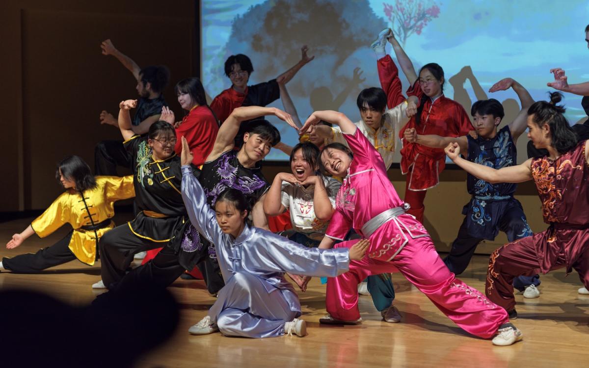 Students performing on stage with traditional wear