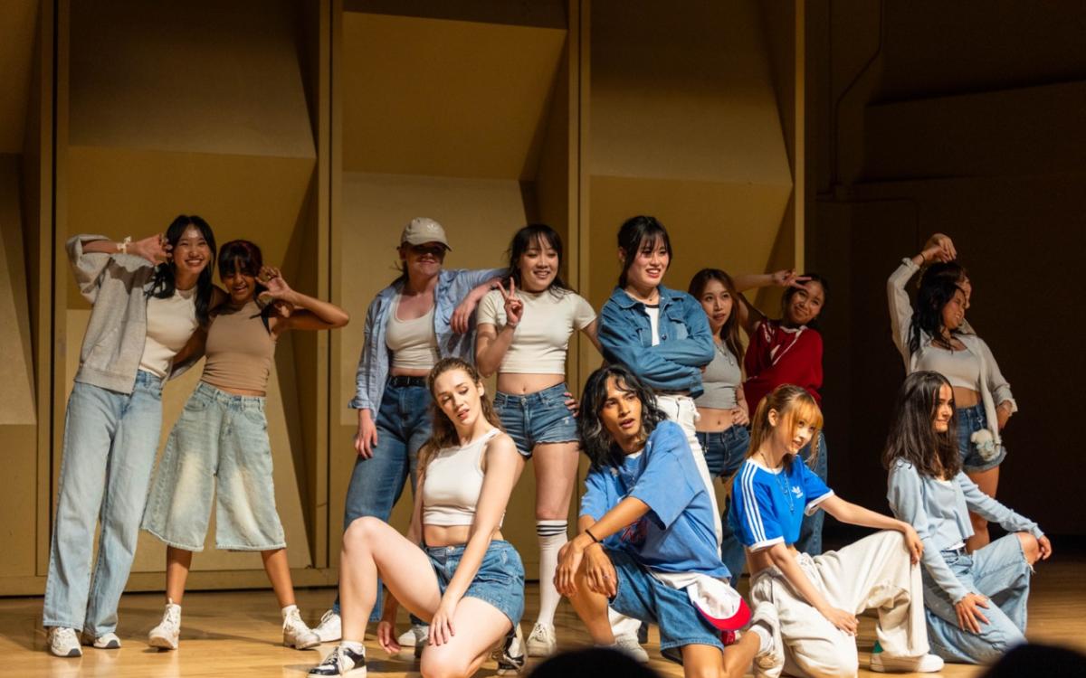 Group of dancers in white a blue outfits.
