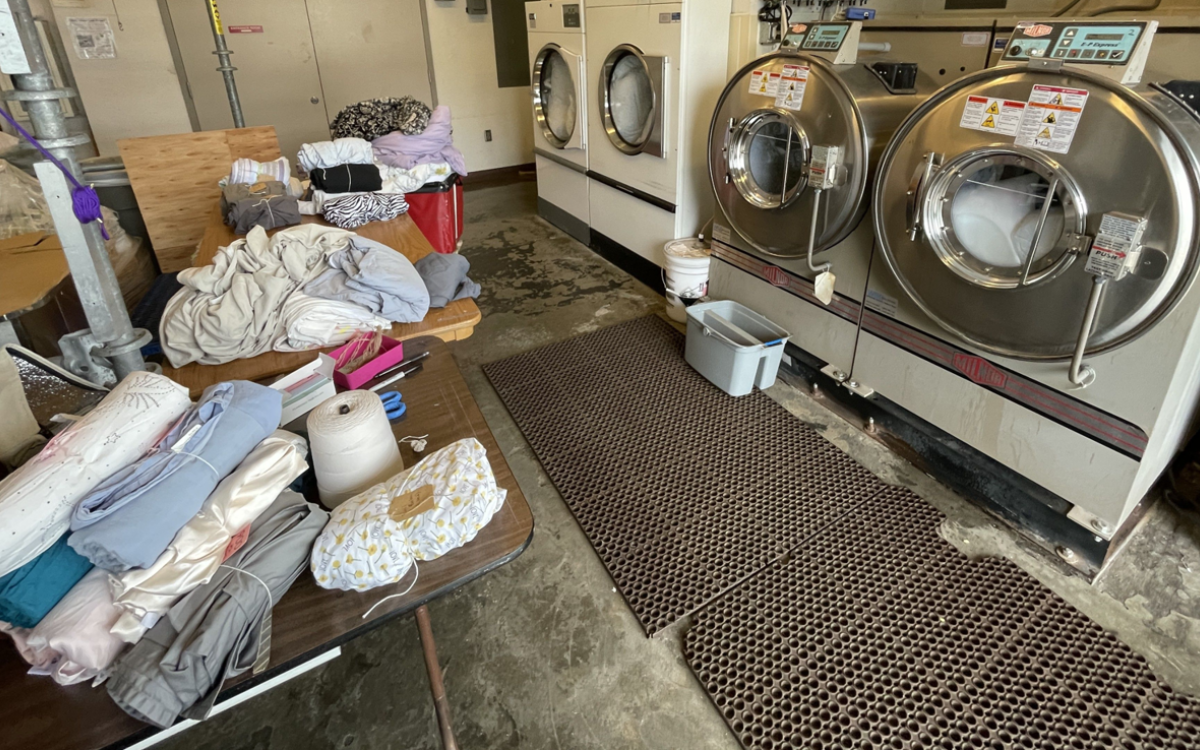 Linen wrapping station in front of commercial washing machines