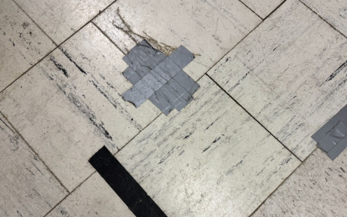 Tile with a large fragment broken off and taped down.